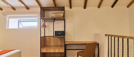 A room with a bed, a desk, a chair, a wooden shelving unit, and a window.