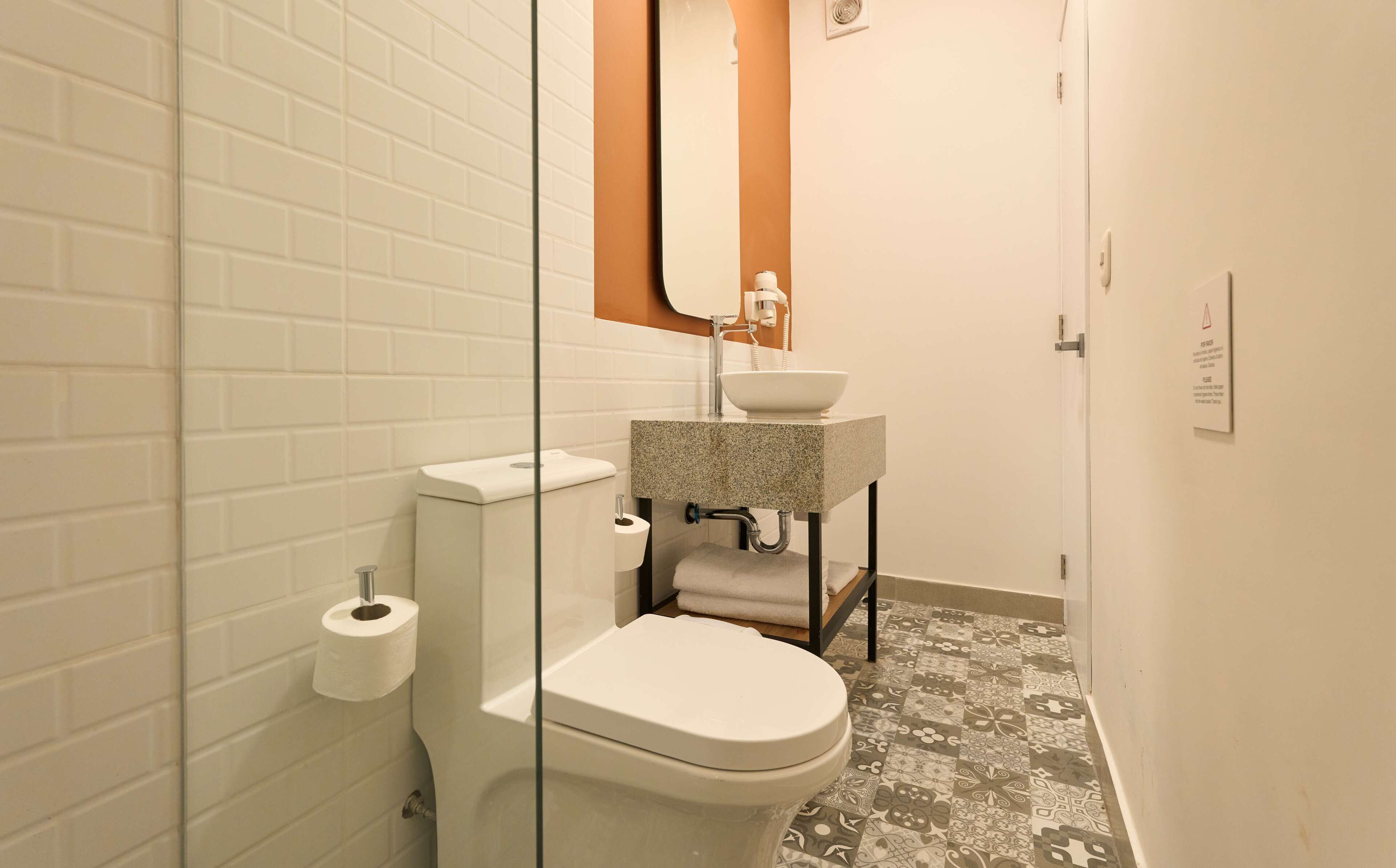 Un baño con inodoro, lavabo y espejo.