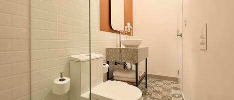 Un baño con inodoro, lavabo y espejo.