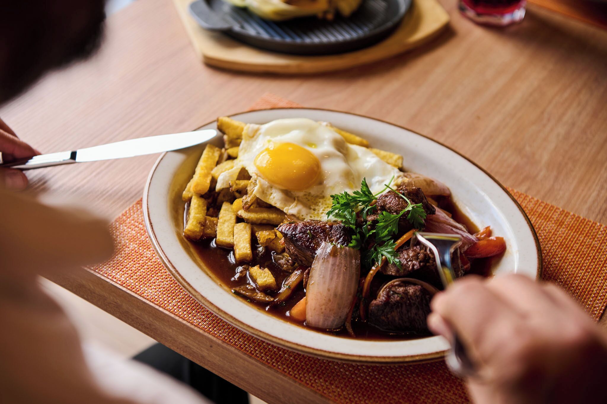 A plate of food with a steak, egg, and fries.