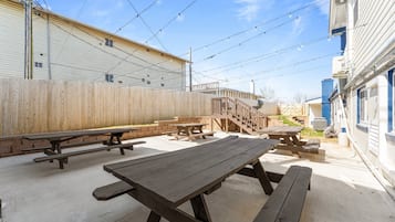 An outdoor patio area with picnic tables and a wooden fence.