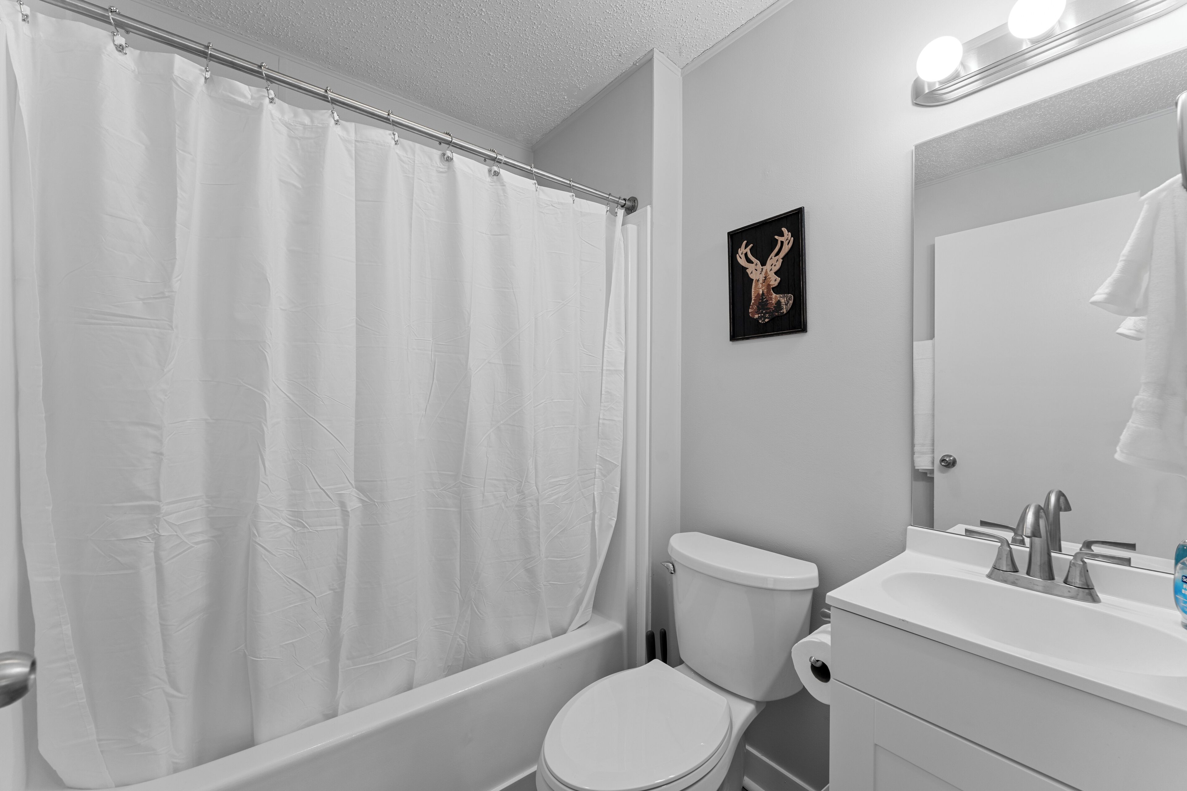 Een badkamer met een badkuip, toilet en wastafel.