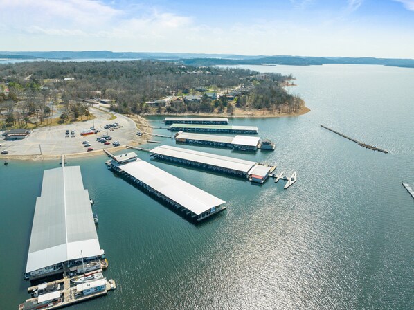 An aerial view of a marina with several docked boats and a large building with a flat roof.