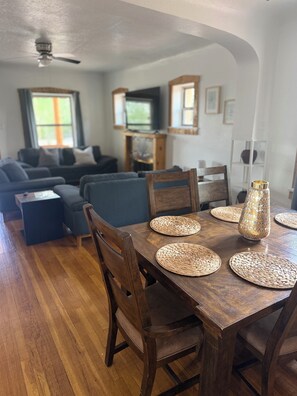 A dining area with a wooden table, woven placemats, and a decorative vase.