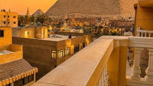 A view of a pyramid with surrounding buildings and a balcony.