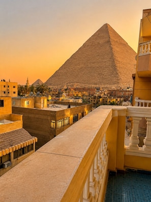 A view of a pyramid with surrounding buildings and a balcony. - Miami Pyramids View (Giza)