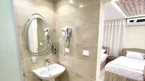 A modern bathroom with a sink, mirror, and hairdryer.