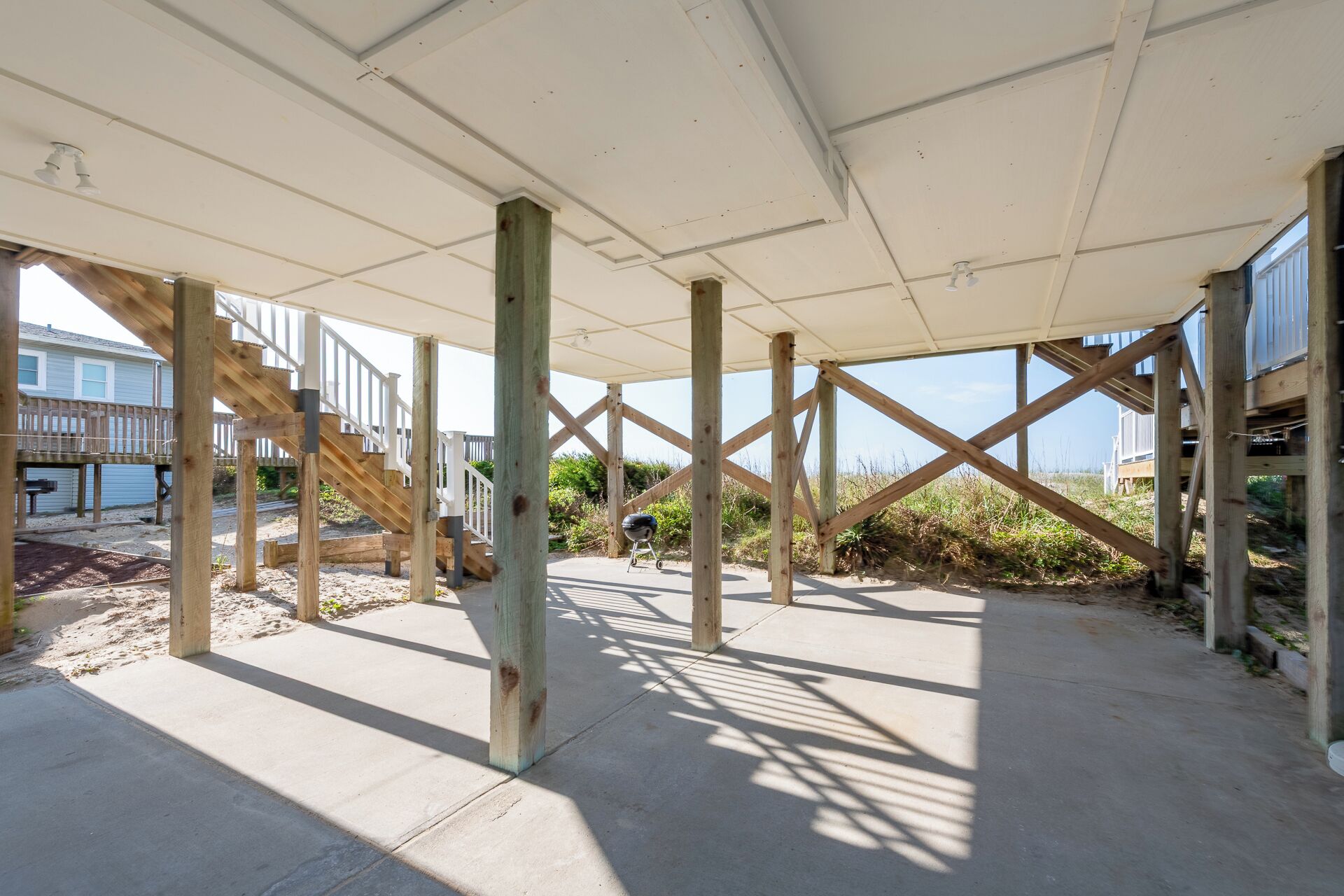 Ein Strandhaus im Bau mit einer Holzterrasse und einer überdachten Veranda.