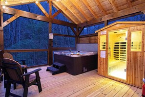 A wooden cabin with a hot tub, seating area, and a sauna. - Creek · Sauna & Hot Tub · Cabin · Game Room (Sevierville)