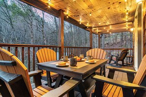 A wooden deck with outdoor seating and string lights. - Creek · Sauna & Hot Tub · Cabin · Game Room (Sevierville)