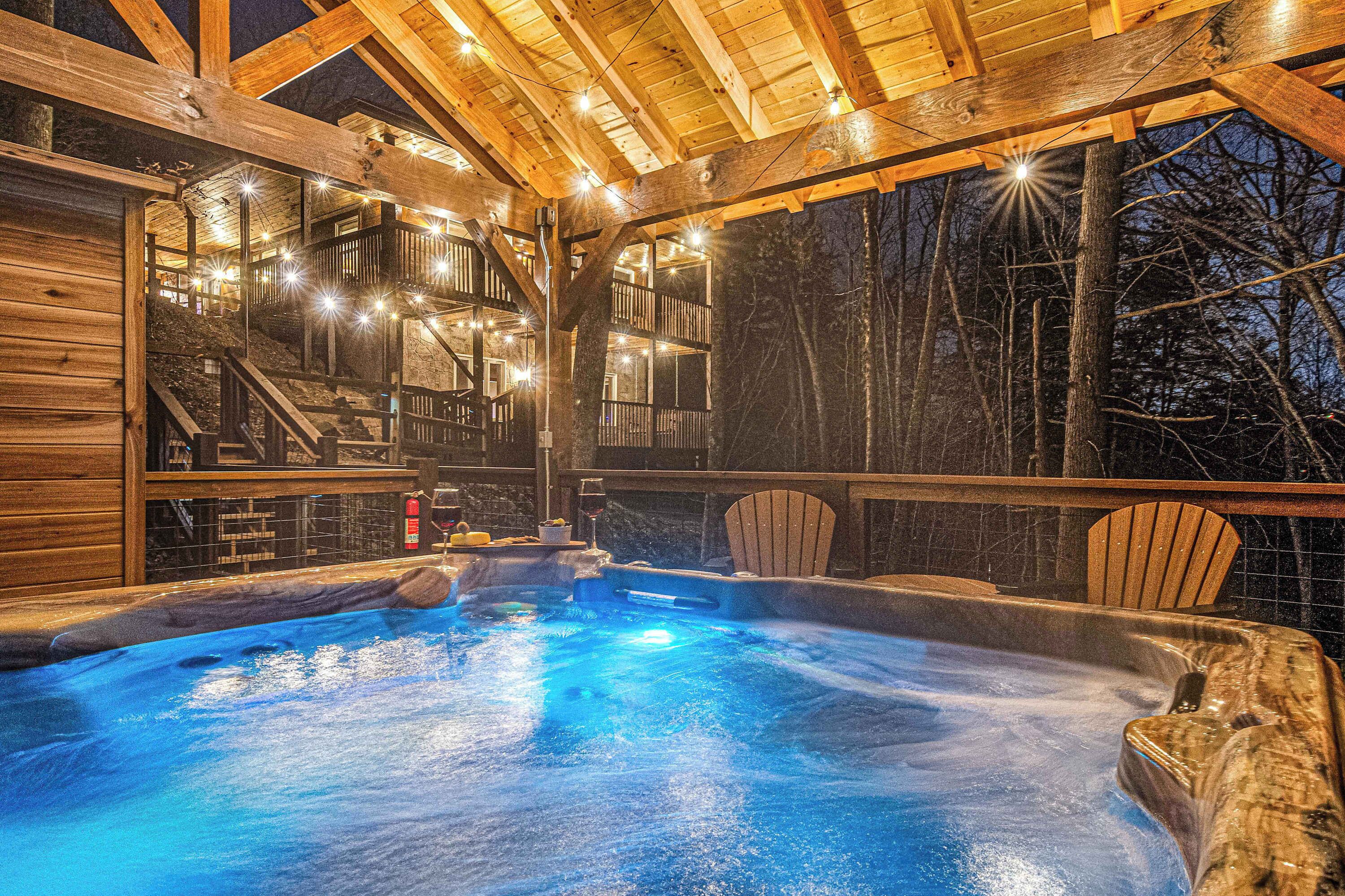 A hot tub area with a wooden deck and a view of trees outside.