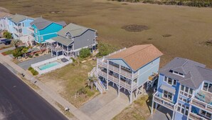 A coastal residential area with houses featuring balconies and a swimming pool.