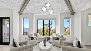A modern living room with a white ceiling, large windows, and a central coffee table. - Experience the Ultimate in Coastal Luxury at A Point of Paradise (Sarasota)