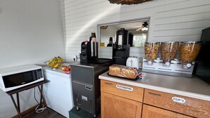 Une petite cuisine équipée d’un four à micro-ondes, d’un grille-pain, d’une machine à café et de distributeurs de céréales.
