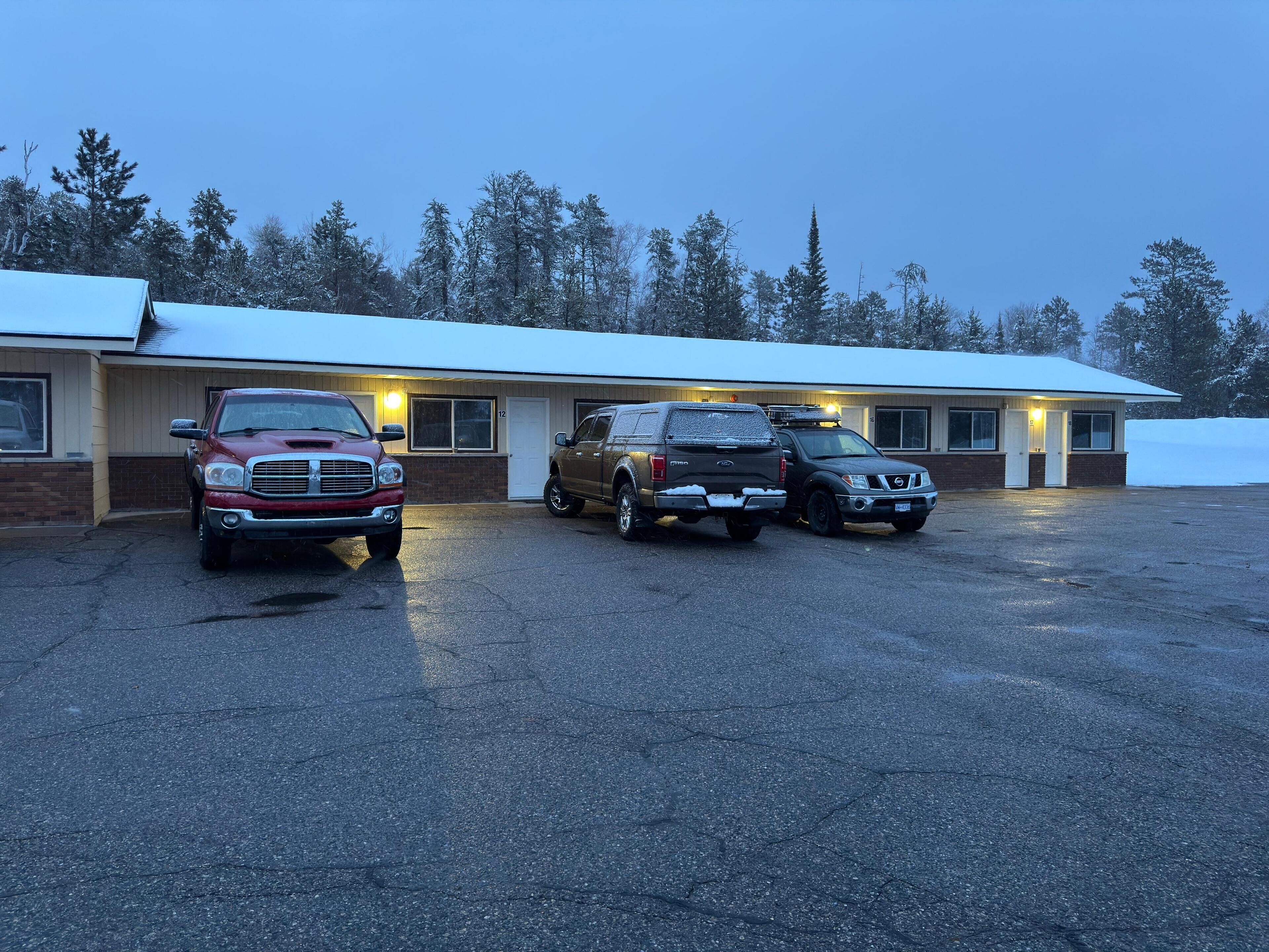 Un motel con tres vehículos estacionados adelante.