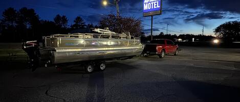 Una caravana grande estacionada en un estacionamiento, con un letrero de motel al fondo.