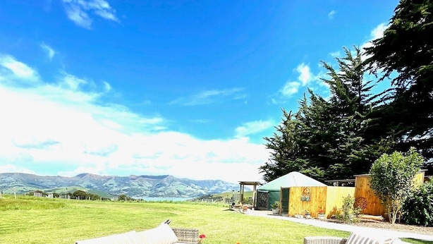 Ein Sitzbereich im Freien mit Korbmöbeln und Blick auf Berge.