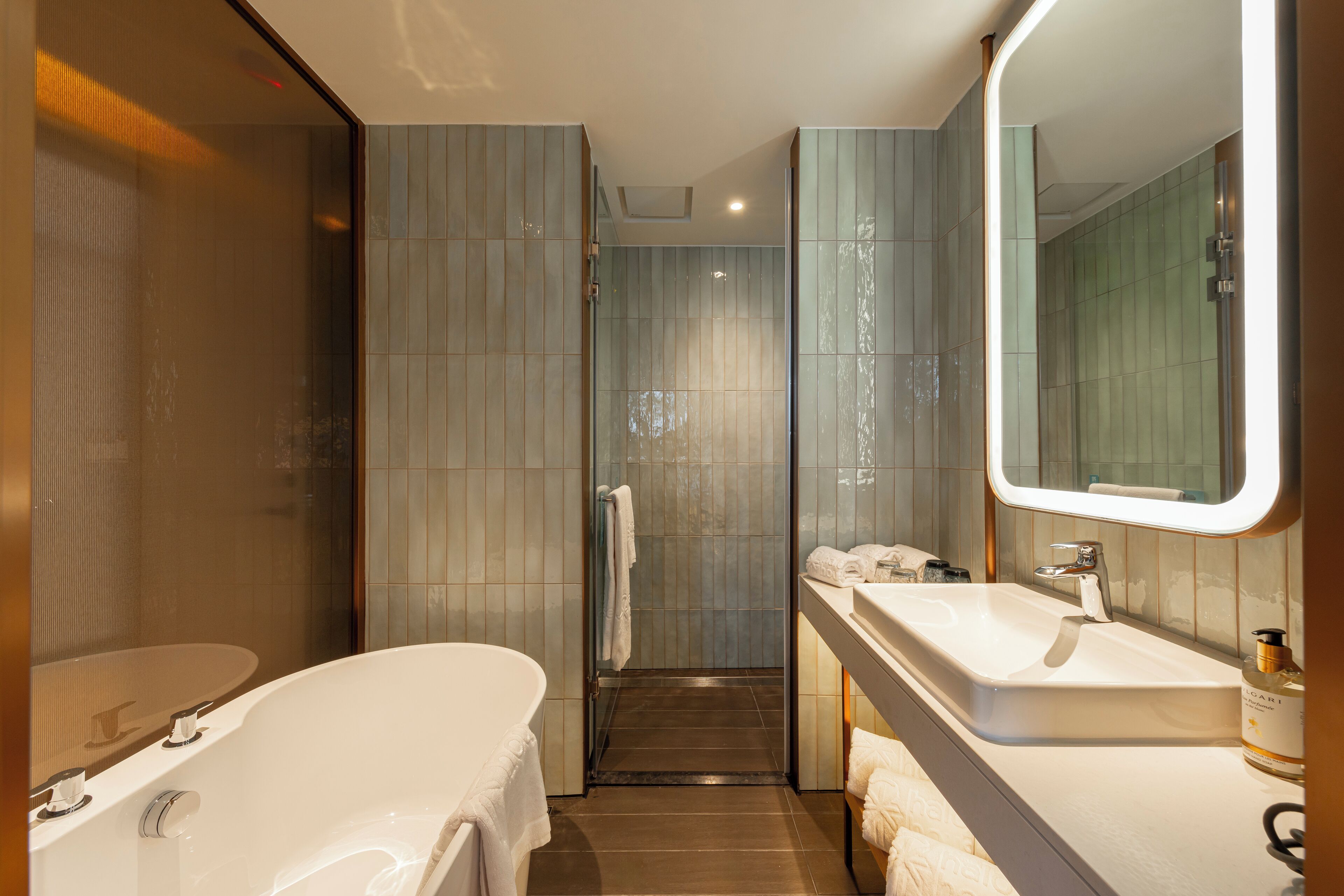 Un baño moderno con una bañera independiente, un tocador con espejo y zona de ducha.