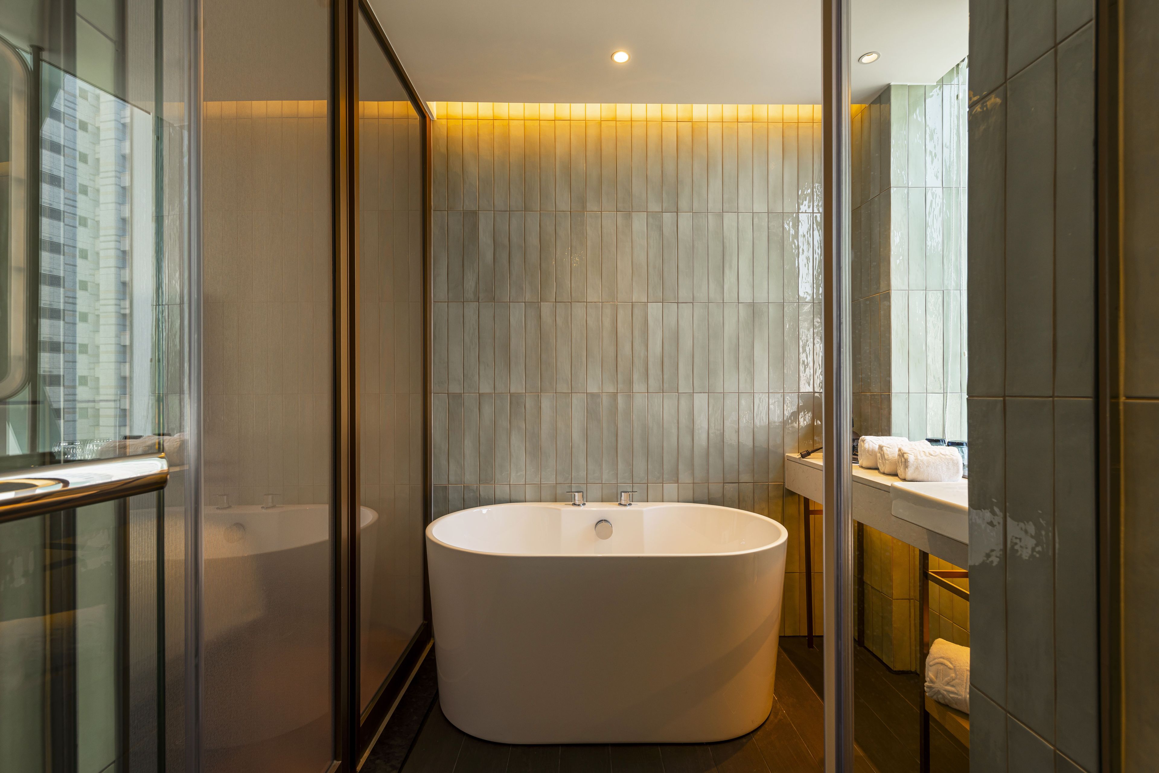 A modern bathroom with a freestanding bathtub, a glass shower enclosure, and a vanity with a mirror.