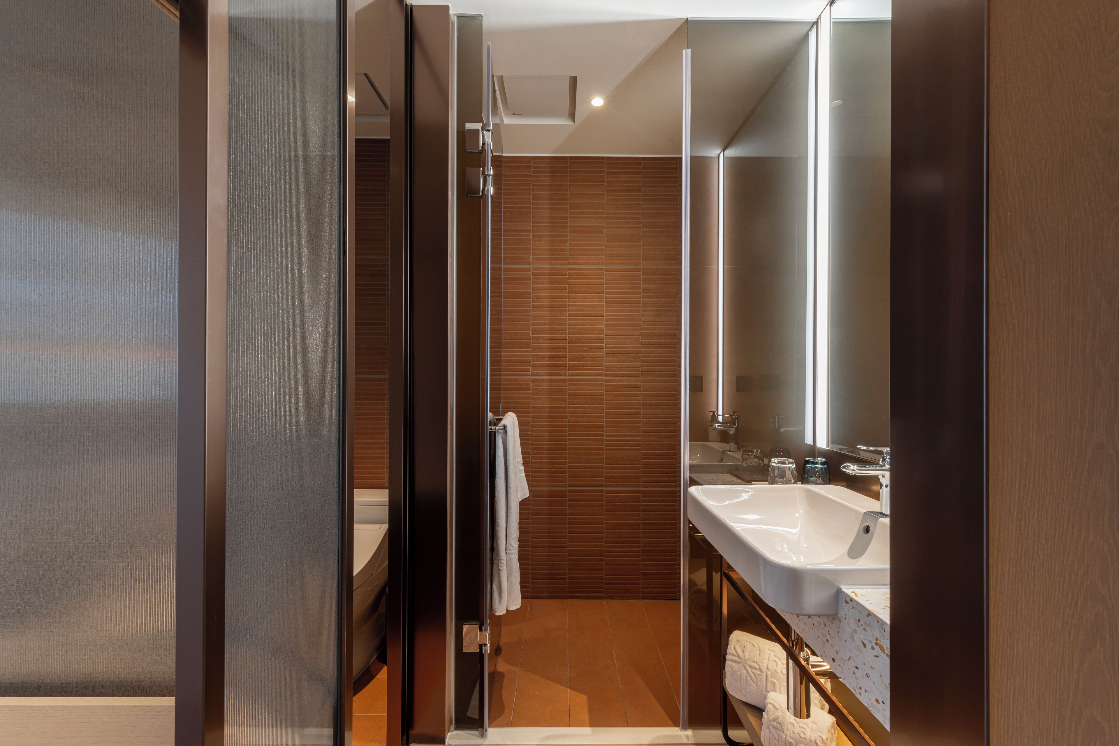 A modern bathroom with a glass shower enclosure, a large mirror, and a dual sink vanity.