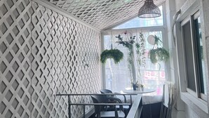 Un intérieur moderne avec un mur orné d’un motif géométrique, un escalier et une vue par la fenêtre.
