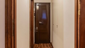 A narrow hallway with a wooden door at the end. - GuestHost - Charming Apartment near Spanish Steps (Rome)