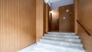 A staircase leading to a room with wooden walls and a tiled floor.
