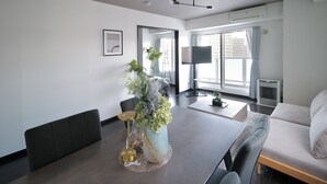 Una sala moderna con una mesa de comedor, sofá y un espejo grande.