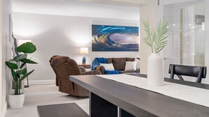 Una sala de estar moderna con un sofá, una mesa de centro y un cuadro grande en la pared.