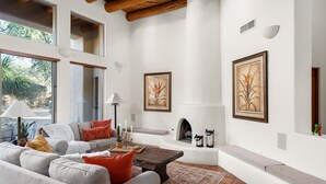 Amplia sala de estar con chimenea, ventanas grandes y un rincón de descanso acogedor.