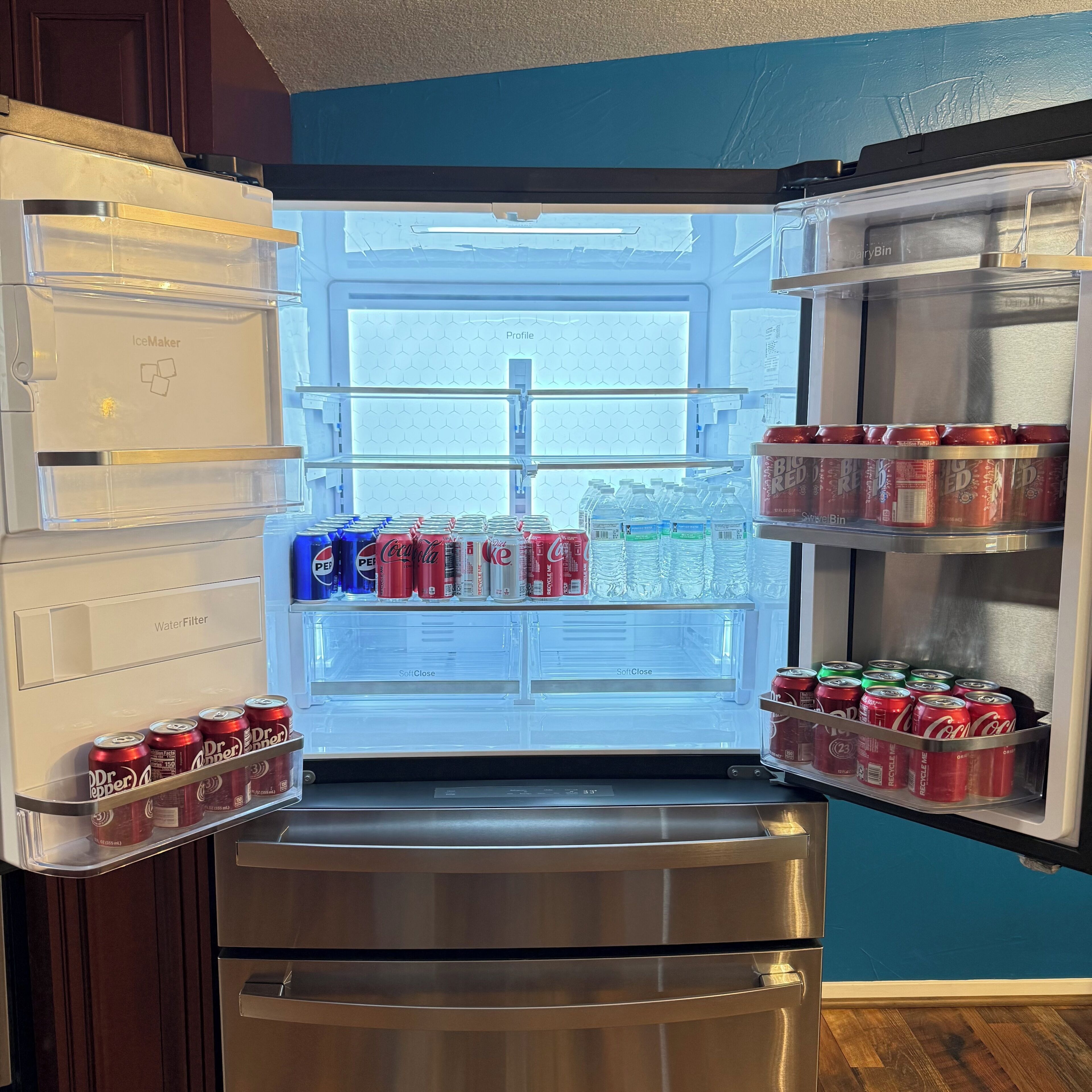 A refrigerator with multiple shelves stocked with various beverages, including soda cans and water bottles.