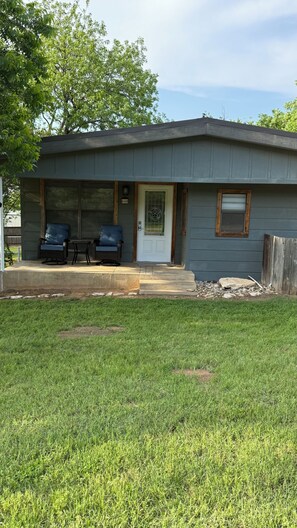 A single-story house with a front porch, a door with a star-shaped window, and a mailbox. - Newly updated home on Spruce St (Mason)