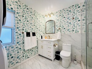 A bathroom with a white vanity, a toilet, and a shower.