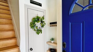 A staircase leading to a white door with a 'Welcome' sign, a blue door with a window, and a sign reading 'Pittsburgh, PA'. - Luxury Private Boutique Hotel with CityView, Hot Tub, Free Parking (Pittsburgh)