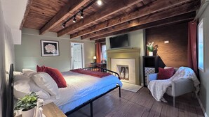 A bedroom with a bed, a fireplace, a TV, and a window. - Luxury Private Boutique Hotel with CityView, Hot Tub, Free Parking (Pittsburgh)
