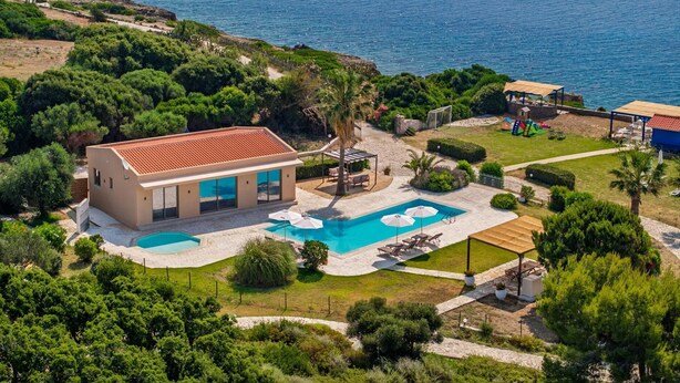 A modern villa with a swimming pool, surrounded by lush greenery and a view of the sea. - Villa Ismini Periyali (Zakynthos)
