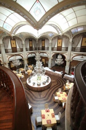 A grand hotel lobby with a central chandelier, multiple dining areas, and a high ceiling with intricate designs. - Hi Inn Jiaotong University Branch (Shanghai)