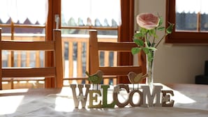 A 'WELCOME' sign with wooden letters, a vase with a rose, and two bird decorations on a table. - Holiday Apartment 'Sum' with Mountain View, Shared Garden, and Wi-Fi (Oberwolfach)