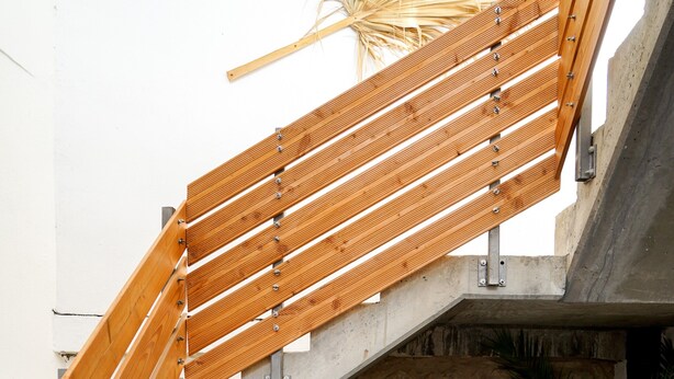 Una escalera de madera con un muro de piedra y un cartel que dice 'welcome'.