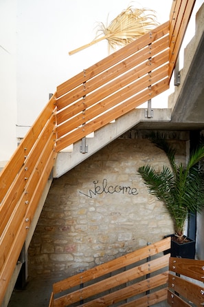 A wooden staircase with a stone wall and a 'welcome' sign. - Apartment 'Heimat - Bad Dürkheim' with Wi-Fi (Bad Dürkheim)
