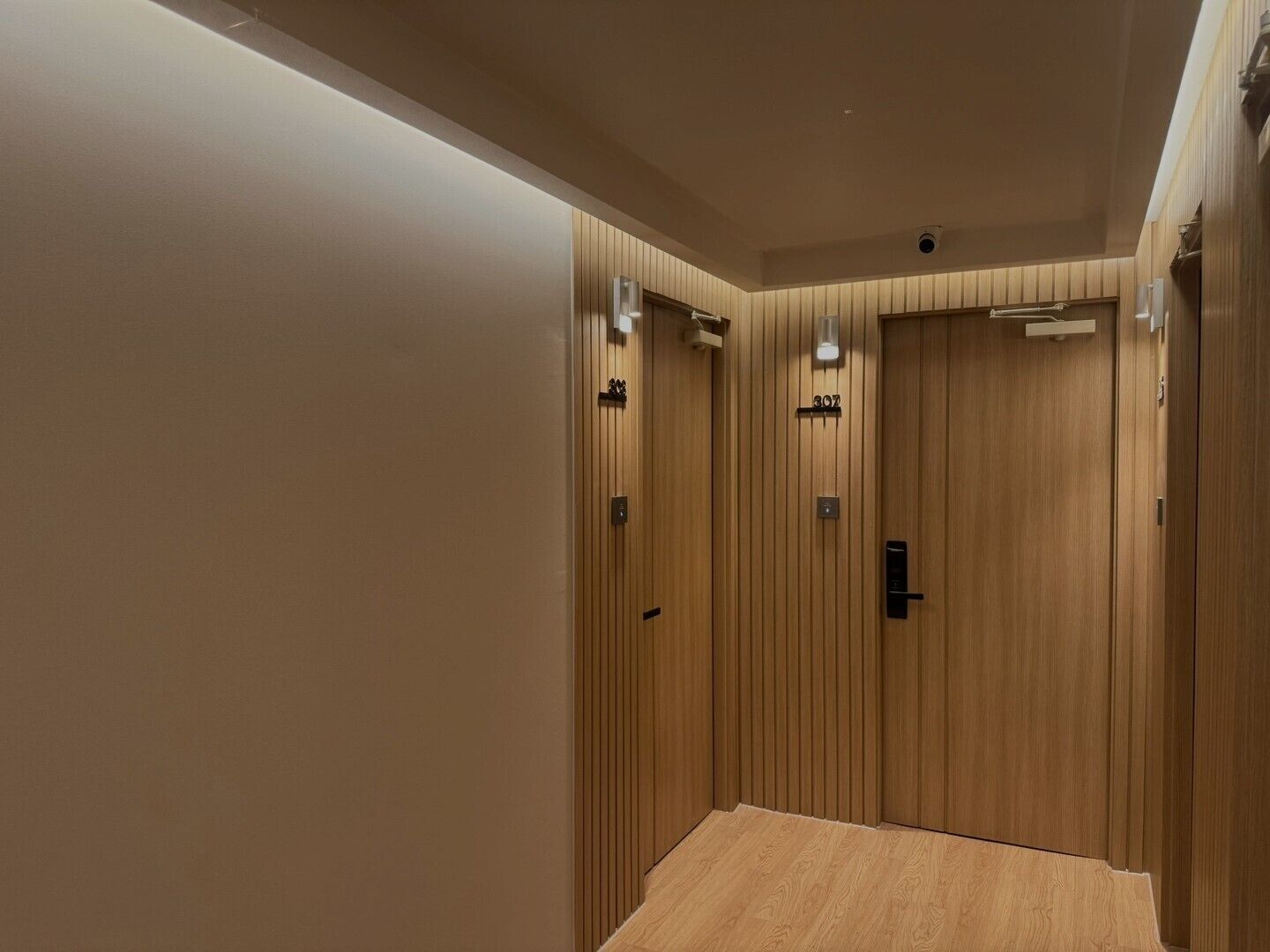 A modern elevator with wooden paneling and a digital display.