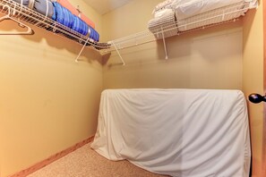 A small, enclosed room with a bunk bed, a drying rack, and a covered mattress.