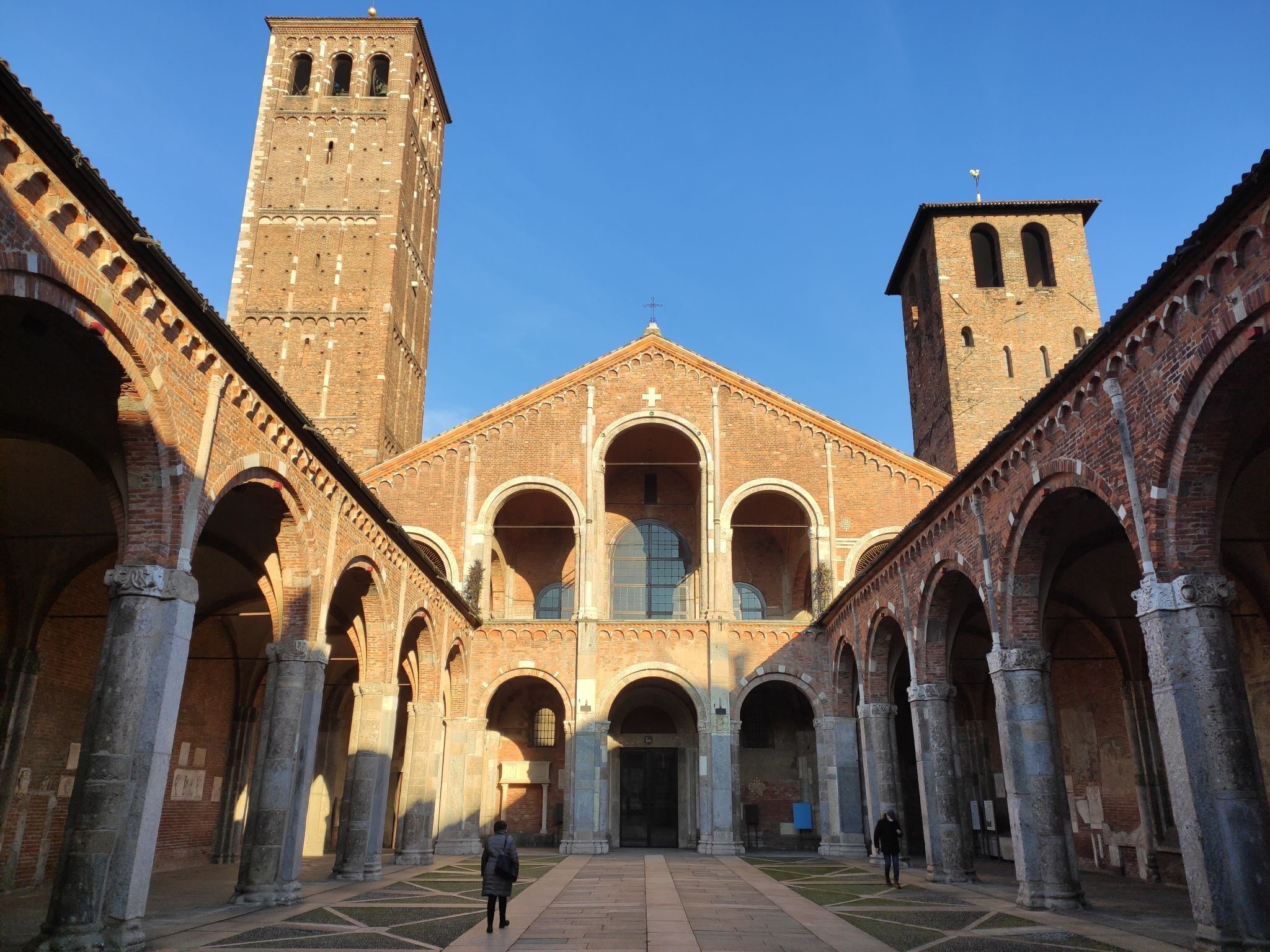 A historic building with a central courtyard, featuring a large arched entrance and two towers.