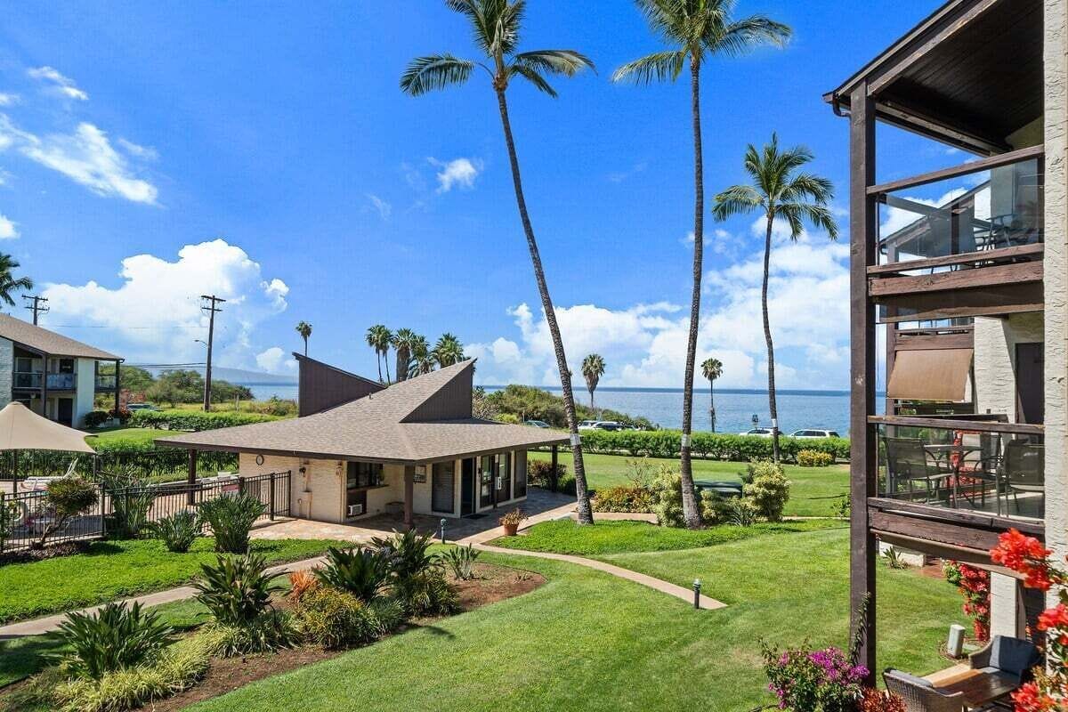 A beachfront property with a covered patio, a pool, and a view of the ocean.