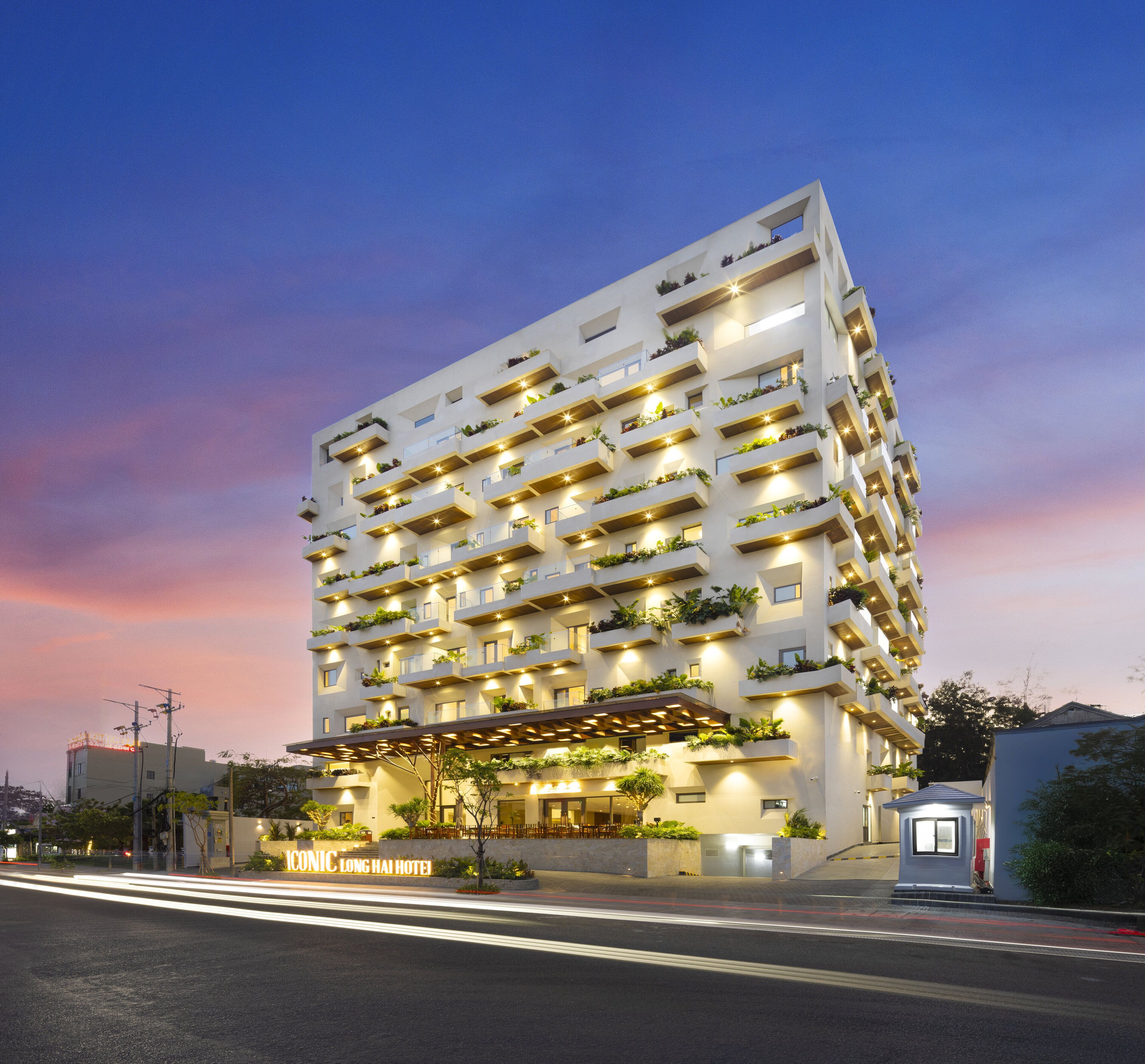 A multi-story hotel with balconies, a covered entrance, and a sign reading "Long Hai Hotel".