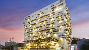 A multi-story hotel with balconies, a covered entrance, and a sign reading "Long Hai Hotel".