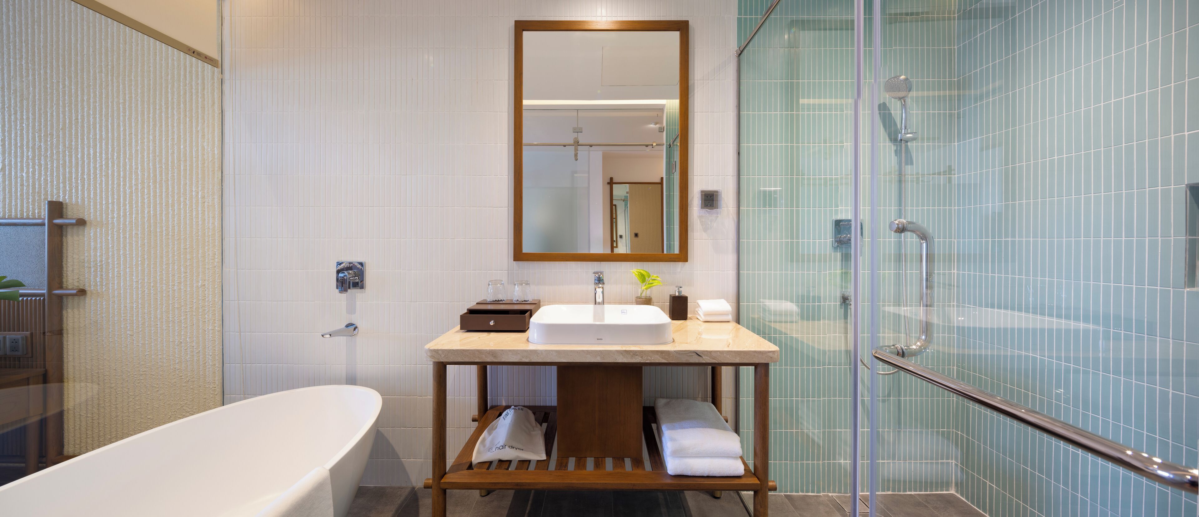 A modern bathroom with a freestanding bathtub, a vanity with a mirror, and a glass-enclosed shower area.