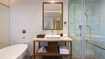 A modern bathroom with a freestanding bathtub, a vanity with a mirror, and a glass-enclosed shower area.