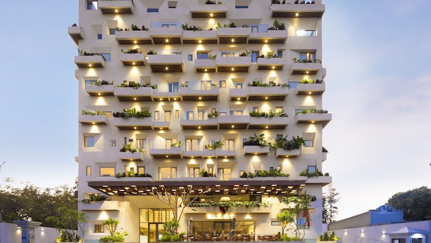 Un hotel de varios pisos con balcones, una entrada cubierta y un letrero que dice 'ICONIC LONG HAIGHT HOTEL'.