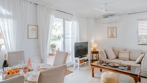 A bright living room with a dining area, a TV, and a sofa. - Xabia Port Plus by Interhome (Jávea)